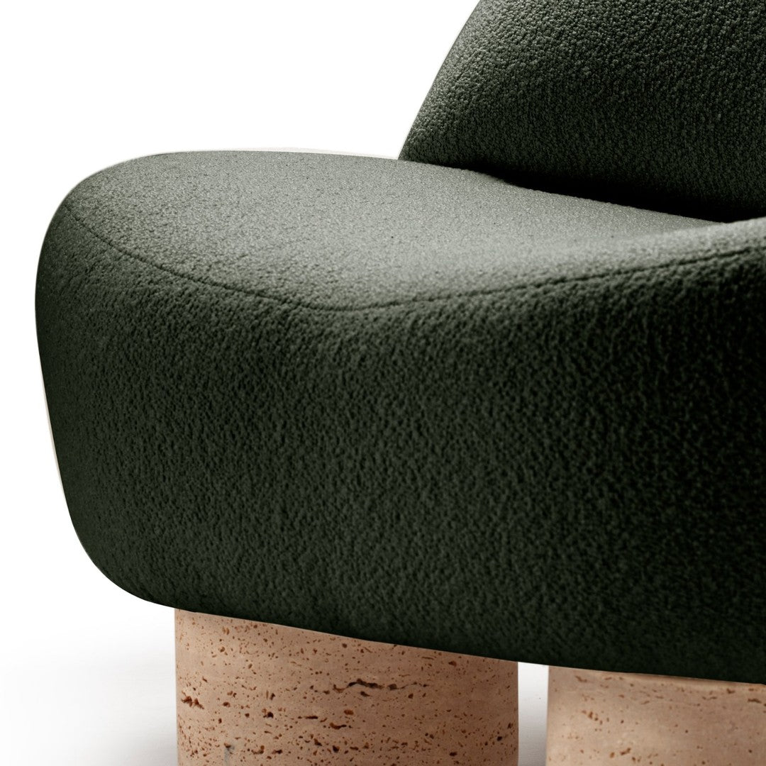 Green textured upholstery with smooth curves and light-colored cork legs. Modern design with earthy tones.