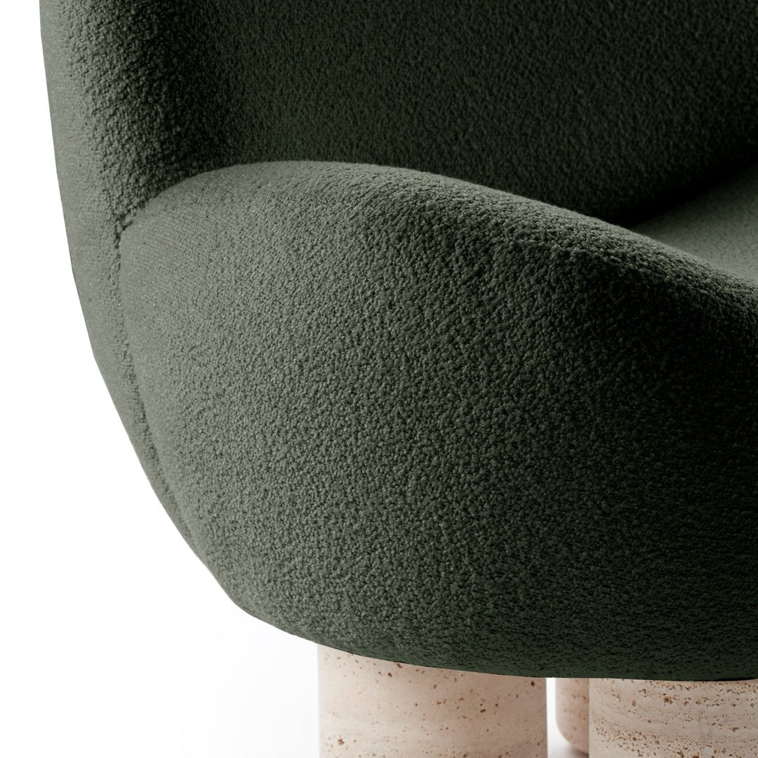 Textured dark green upholstery on a stylish chair with contrasting light stone legs.