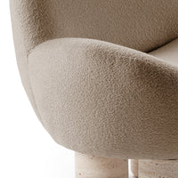 Beige textured upholstery with a soft, cozy appearance, paired with smooth light-colored, rounded legs.
