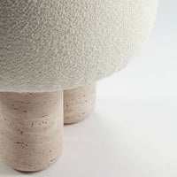 Textured white lamp base with soft, round shape and natural beige stone legs. Modern minimalist design elements.