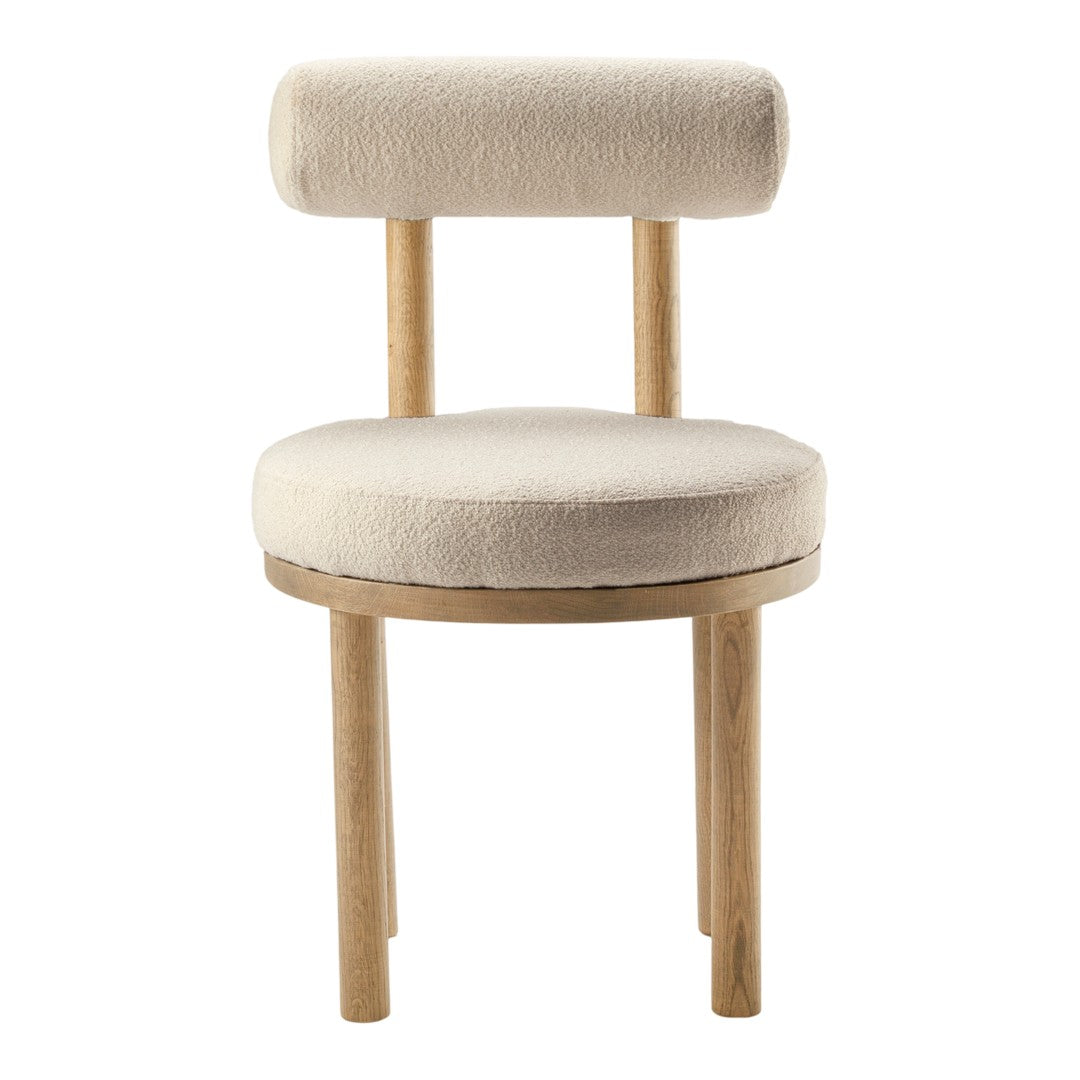 Beige upholstered chair with a round seat and cylindrical backrest, featuring natural wood legs. Soft, minimalist design.