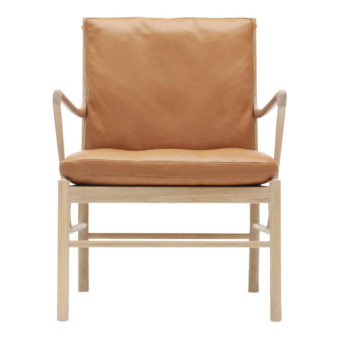 Tan leather armchair with a minimalist wooden frame, featuring smooth surfaces and clean lines for a modern look.