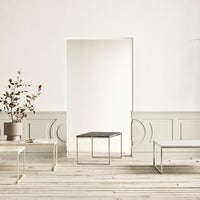 Minimalist square coffee table with a sleek black surface and thin silver frame, set against a neutral backdrop.