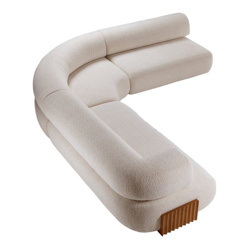 Beige curved sofa with a textured finish and wooden accent, perfect for a modern living space.