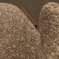 Brown speckled upholstery fabric with subtle texture, complemented by a wooden accent. Perfect for modern decor.