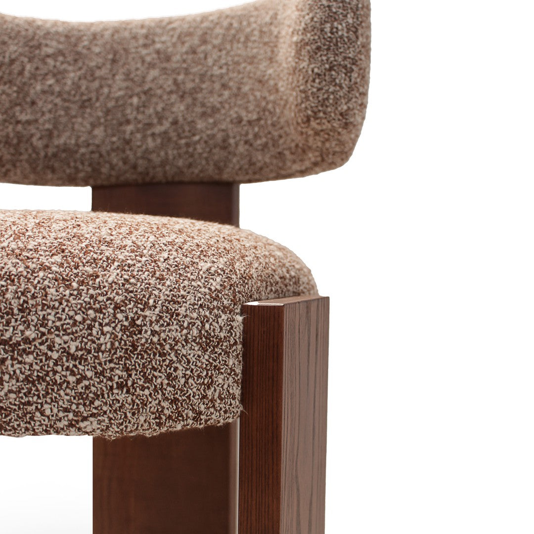 Brown textured upholstery with a soft, fluffy pattern on a wooden chair leg. Elegant and modern design.