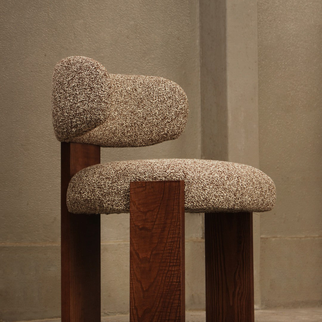 Beige textured upholstery with a fuzzy pattern on a wooden chair, featuring natural brown legs.