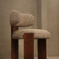 Beige textured upholstery with a fuzzy pattern on a wooden chair, featuring natural brown legs.