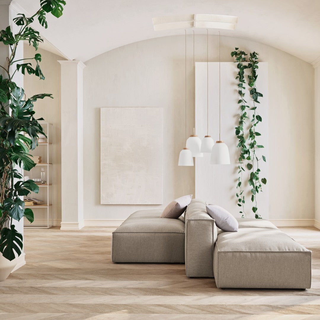 Modern living space with light beige furniture, neutral tones, green plants, and a subtle wood-patterned floor.