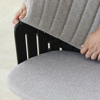 Gray striped fabric cushion on a black wooden chair, showcasing sleek patterns and modern design.