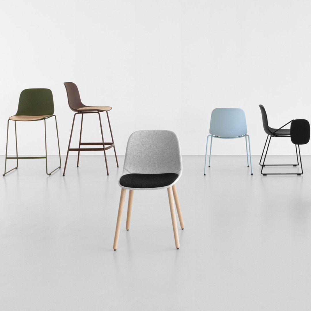 Colorful collection of modern chairs featuring gray, green, brown, blue, and black fabrics with wooden and metal legs.