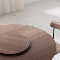Round wooden table with rich brown tones and sleek surface pattern, featuring a circular inset. Modern and elegant design.