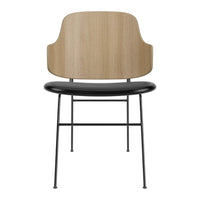Modern chair in natural wood tones with a sleek black seat and minimalist metal legs. Stylish and contemporary design.