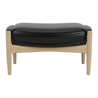 Black leather ottoman with light wooden legs, featuring a smooth, curved design. Perfect for modern interiors.
