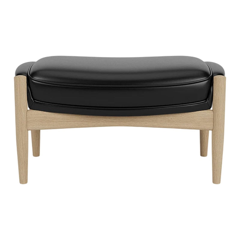 Black leather ottoman with light wooden legs, featuring a smooth, curved design. Perfect for modern interiors.