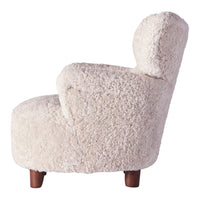 Soft cream-colored chair with a textured, fluffy fabric and wooden legs, perfect for cozy interiors.