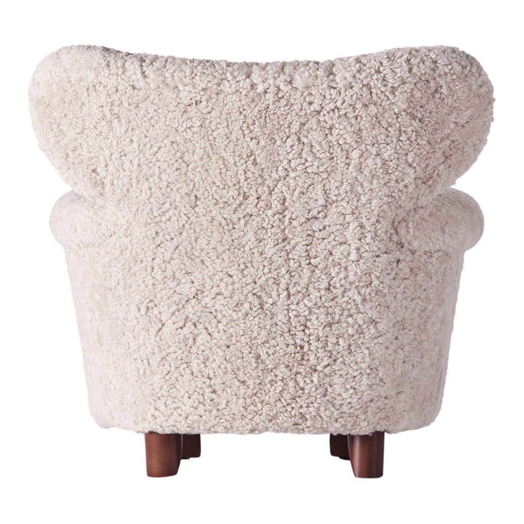 Light beige, textured fur upholstery with plush curves and dark wood legs. Soft, cozy design for modern interiors.