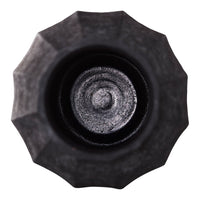 Close-up of a textured black bottle cap with a circular pattern at the center and a star-shaped outer design.