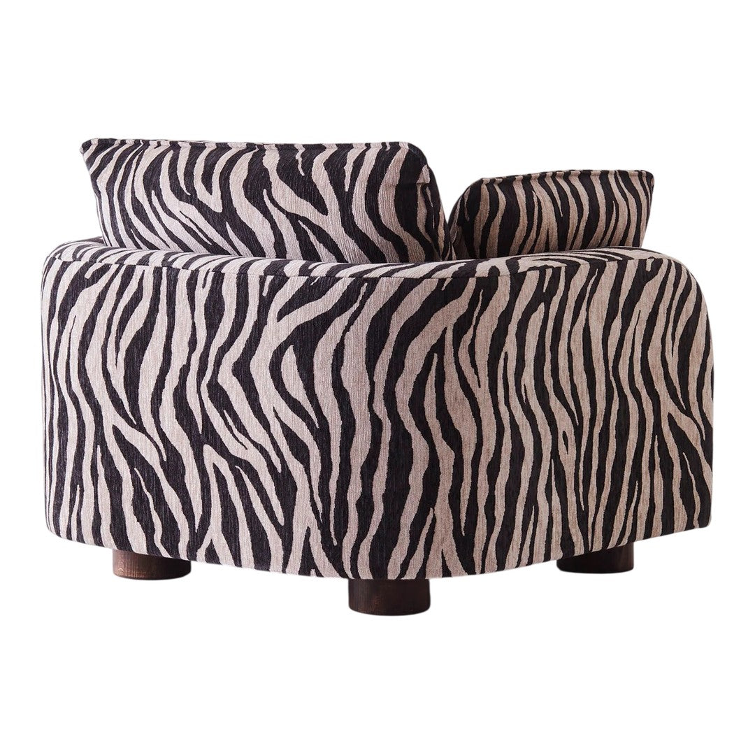 Zebra-patterned accent chair in black and cream, featuring a curvy design and wooden legs. Perfect for bold decor.