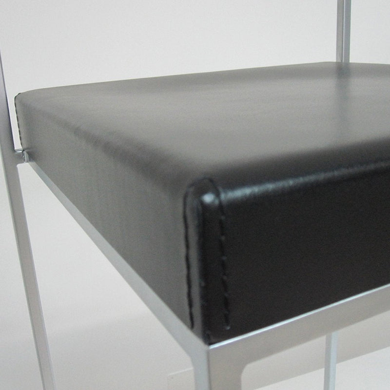 Black leather seat cushion with smooth texture and sleek silver metal frame. Modern design for stylish interiors.