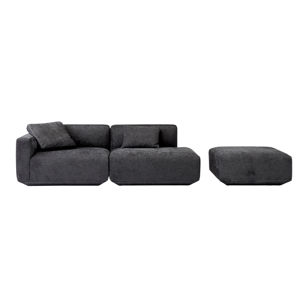 Modern dark gray sectional sofa with plush texture, featuring clean lines and a matching ottoman. Perfect for contemporary spaces.