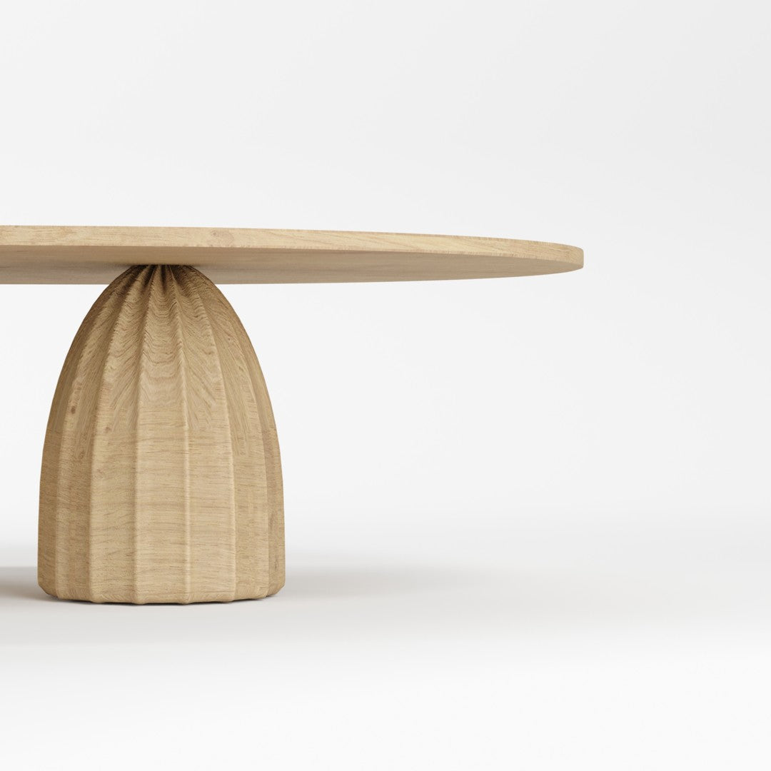 Natural wood round table with a smooth top and a fluted base, showcasing light beige tones and a minimalist design.