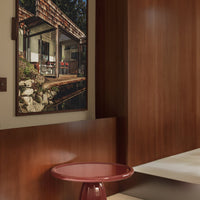 Rustic wooden tones, deep red table, and natural stone accents in a modern interior setting.