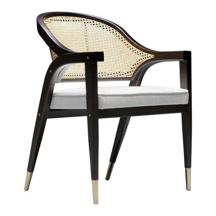 "Elegant black and natural cane chair with white cushion and gold-tipped legs, showcasing a modern design."