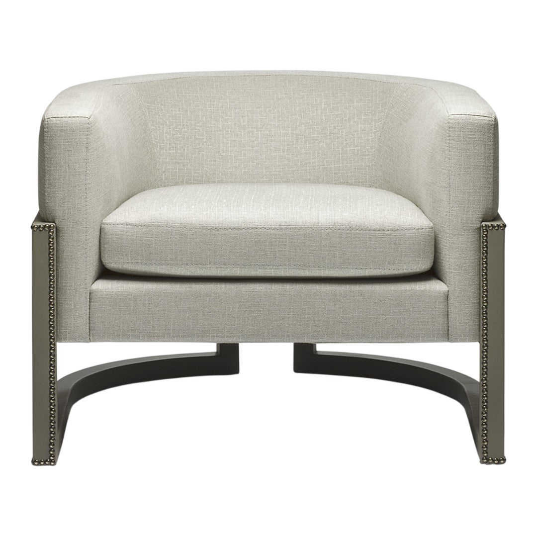 Light beige upholstered armchair with subtle texture and sleek black metal base, featuring nailhead trim detail.