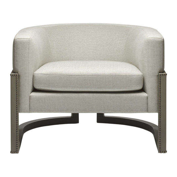 Light beige upholstered armchair with subtle texture and sleek black metal base, featuring nailhead trim detail.