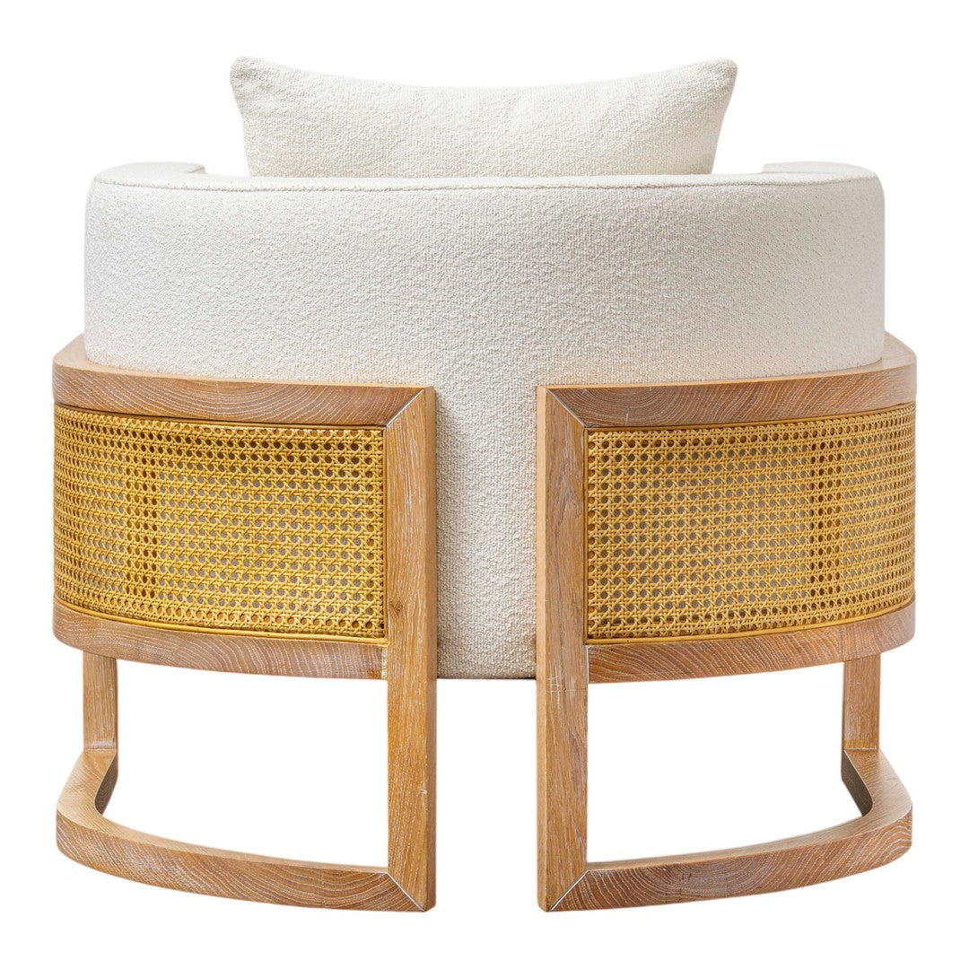 White upholstered chair with natural wood and contrasting woven cane details, featuring a plush cushion.