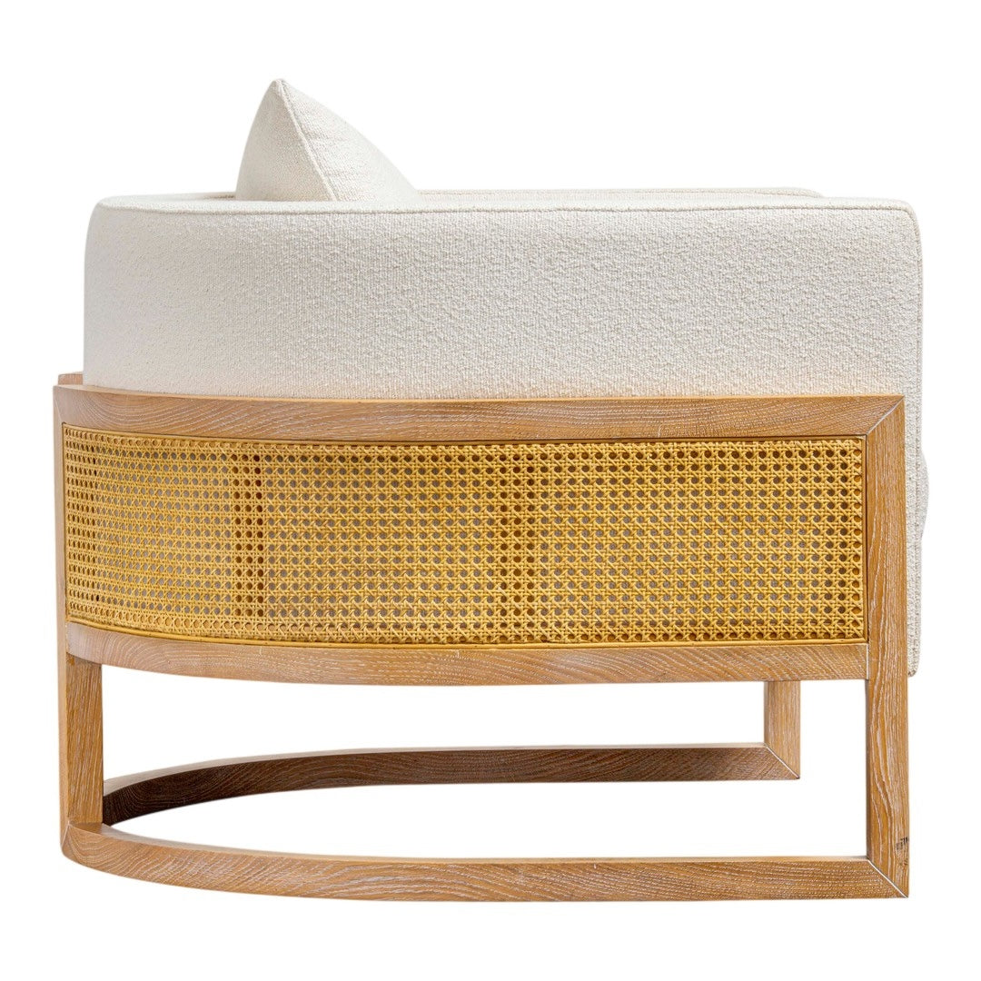 "Round cream upholstered chair with natural rattan and light wood base, featuring a smooth, minimalist design."