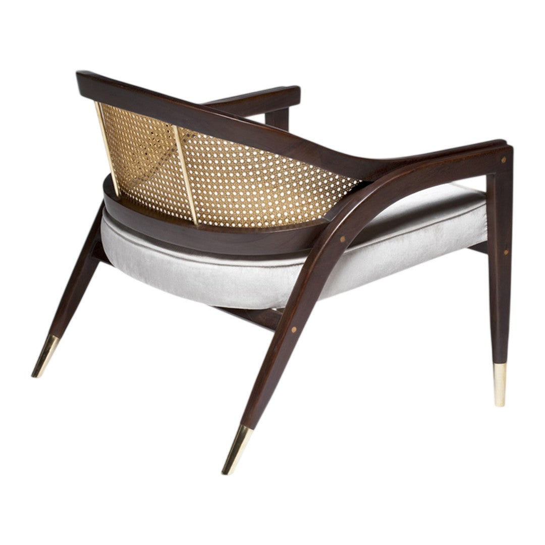 Mid-century chair featuring dark wood frame, natural caning, a soft gray cushion, and brass-tipped legs.