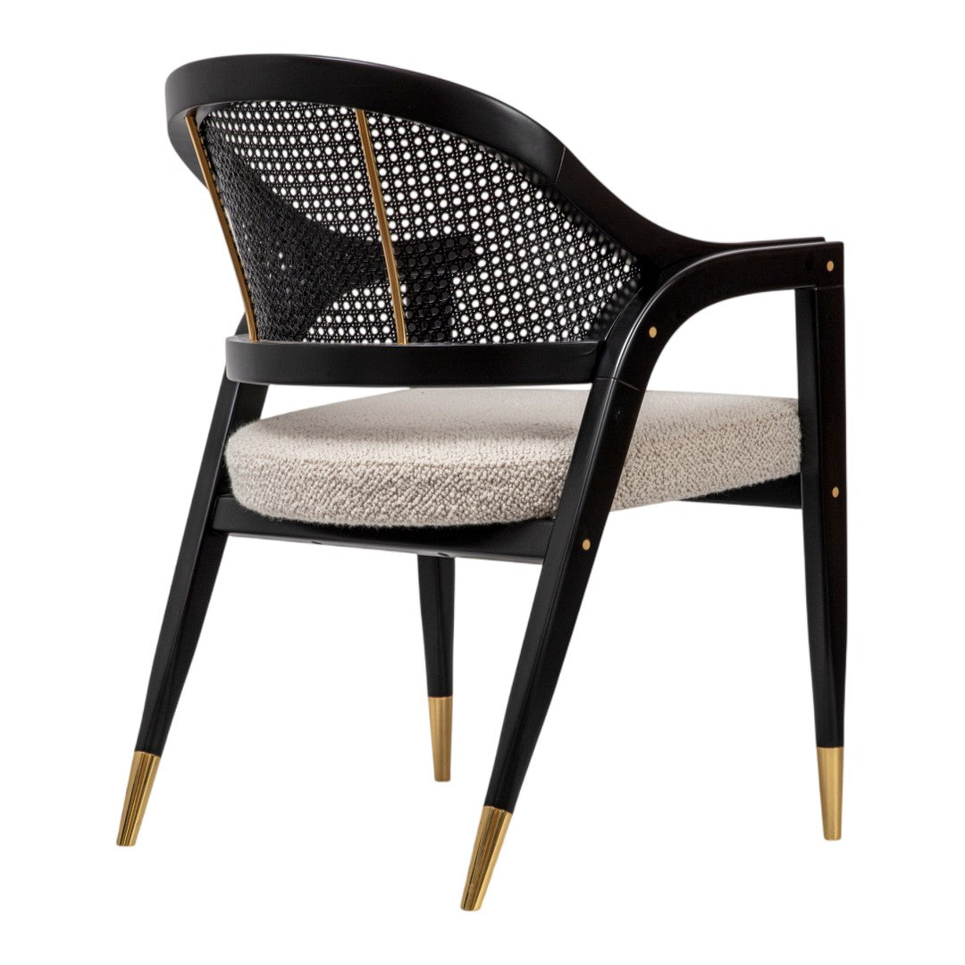 Black cane chair with a beige cushion, featuring gold accents on the legs for a modern and elegant look.