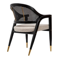 Black cane chair with a beige cushion, featuring gold accents on the legs for a modern and elegant look.
