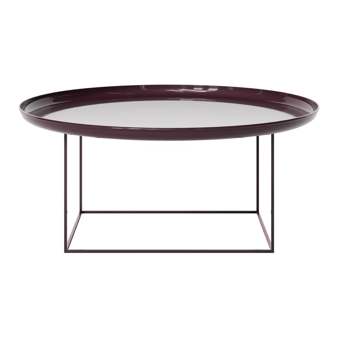 Round burgundy tray table with a sleek glass top and minimalist black metal base, perfect for modern decor.