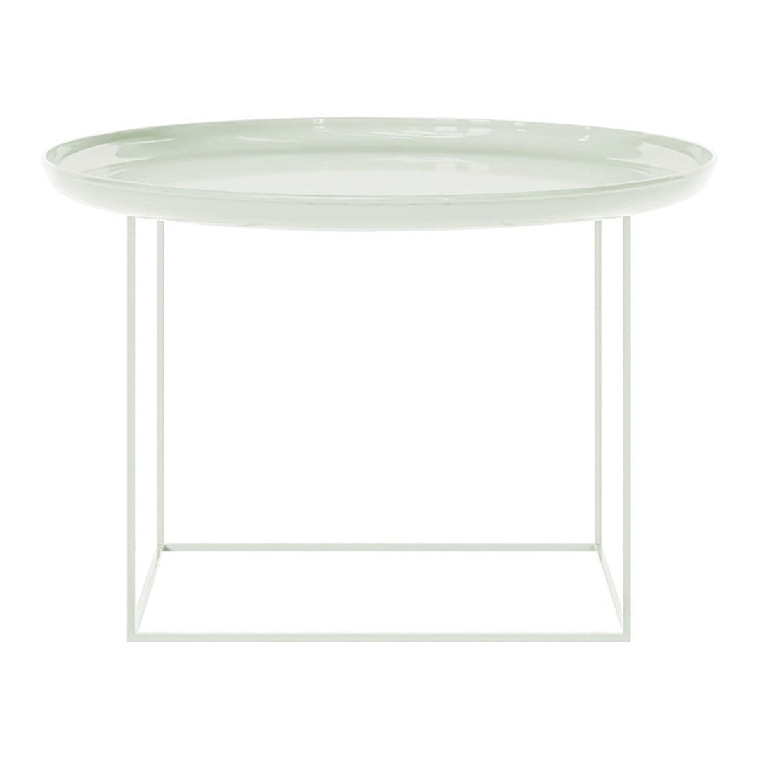 Modern round side table with a soft green glass top and a minimalist white metal frame. Stylish and elegant design.