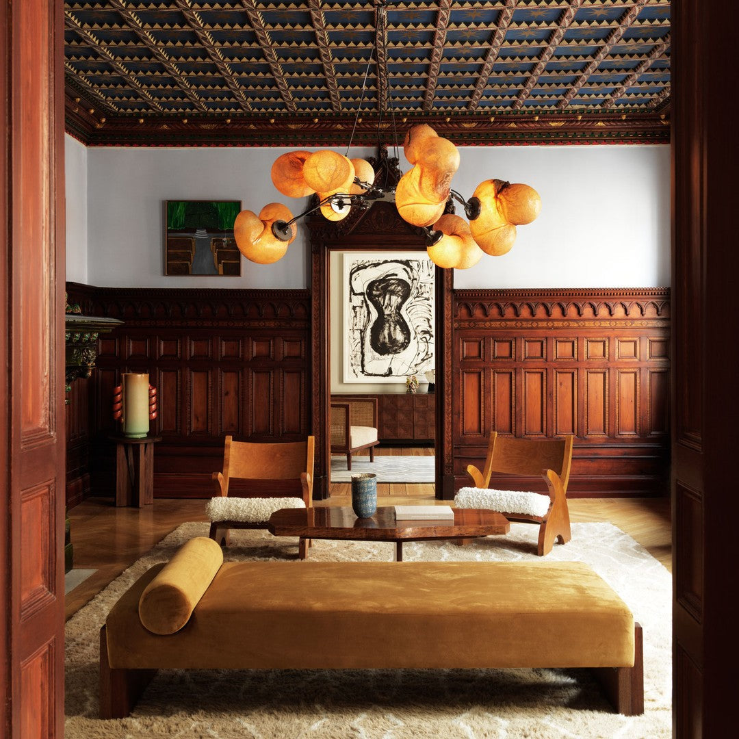 Warm yellow tones, intricate blue ceiling patterns, and rich wooden textures in a sophisticated living room setting.