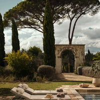 "Elegant neutral tones with lush green foliage and textured stone patterns, creating a tranquil outdoor atmosphere."