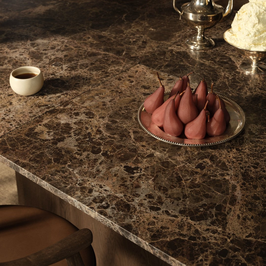 Brown marbled tabletop featuring elegant patterns with soft pink pears and a white decorative piece.