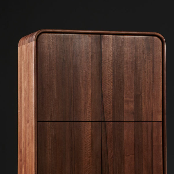 Elegant walnut wood cabinet featuring rich brown tones and smooth lines against a black background.