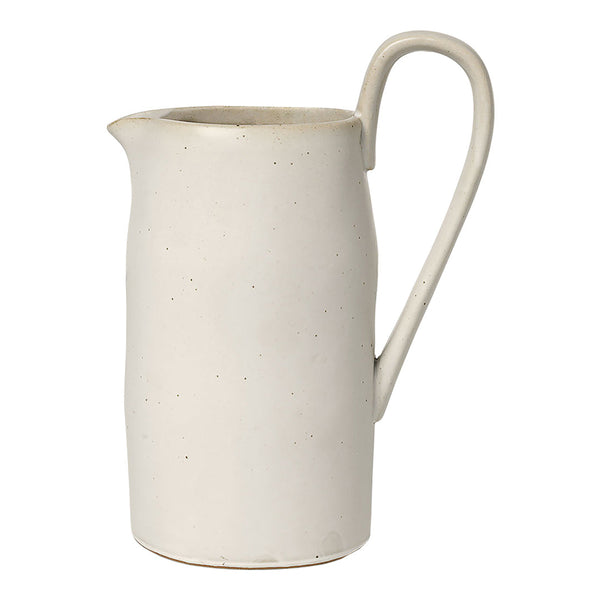 Cream-colored ceramic pitcher with a smooth, matte finish and subtle speckles. Elegant, minimalist design.