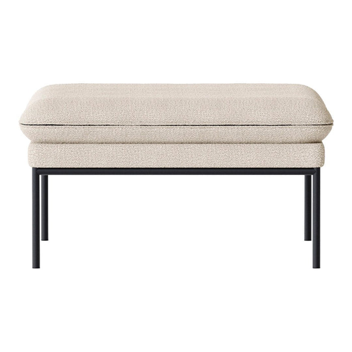 Beige upholstered ottoman with a smooth texture and minimalistic black metal legs. Modern and elegant design.