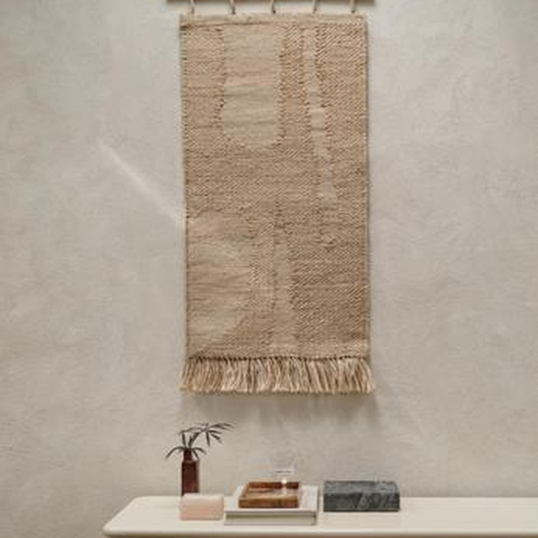 Beige wall hanging with textured patterns and fringe detail, perfect for adding warmth to any interior space.