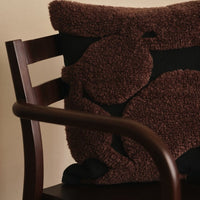 Textured brown and black pillow with abstract patterns, perfect for adding warmth and style to any space.