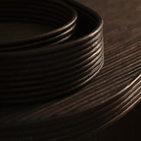 Dark brown textured wood with smooth, rounded edges; circular patterns create an elegant, modern look.