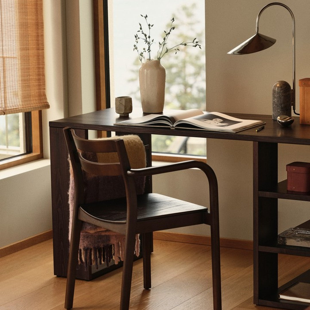 "Modern wooden desk with a neutral palette, striped throw, and soft beige curtains, creating a warm, inviting workspace."