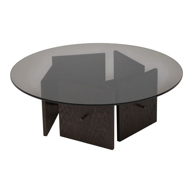Round coffee table featuring a smoky glass top and dark wood geometric base. Sleek, modern design with elegant contrasts.