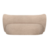 Beige curved sofa in a soft, textured fabric, showcasing a minimalist design and smooth, seamless contours.