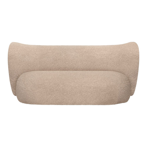 Beige curved sofa in a soft, textured fabric, showcasing a minimalist design and smooth, seamless contours.